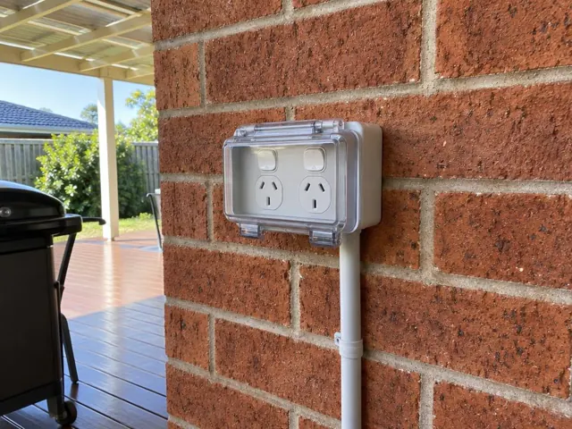 Double outdoor power point on a brick house wall beside a covered deck in Metford